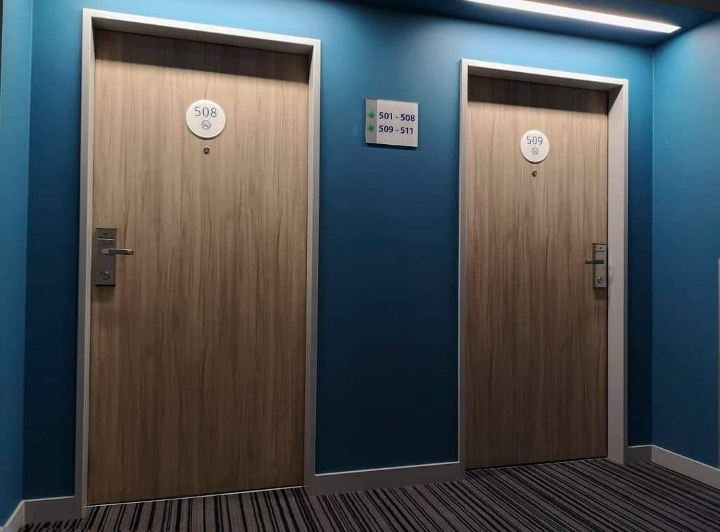 after Hotel doors wrapped in wood-effect vinyl